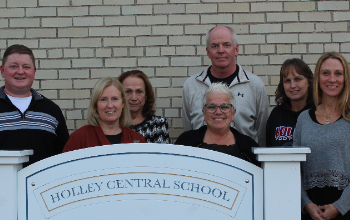 board members standing behind district sign