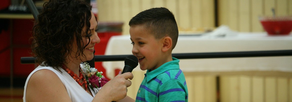 student talking into microphone that teacher is holding