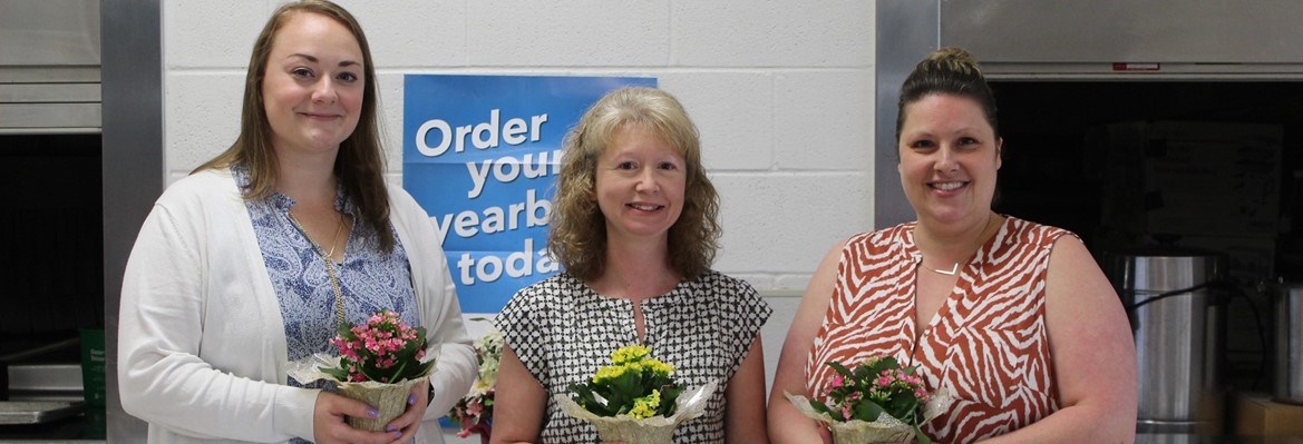 three women holding plants