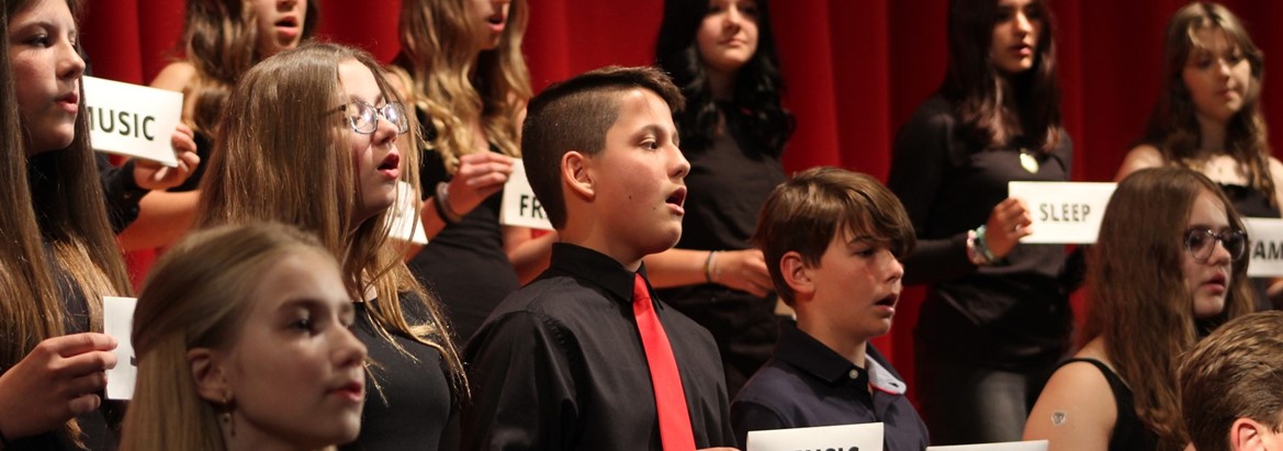 students singing holding signs