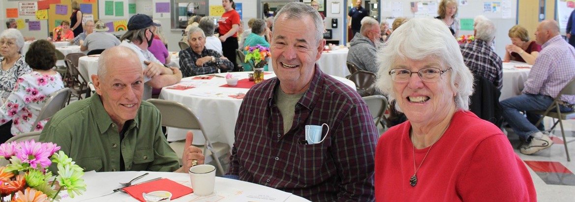 three senior citizens sitting at table