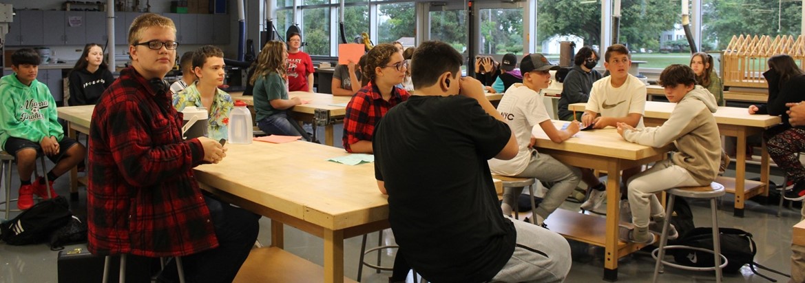 students sitting at tables in technology classroom