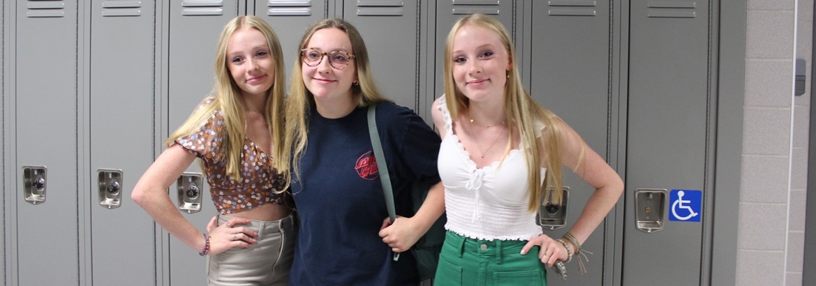 three girls standing in front of lockers