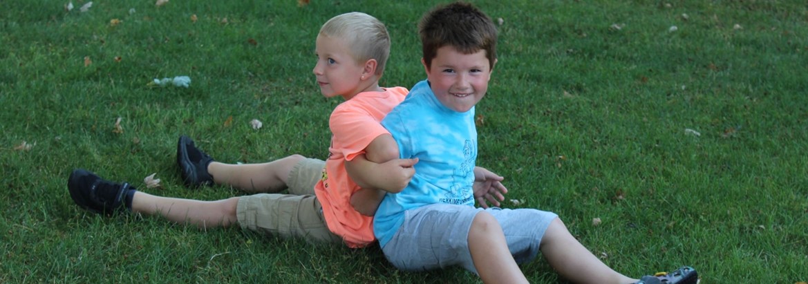 two boys playing on ground