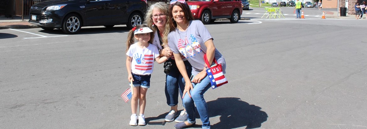 two women and little girl standing in street