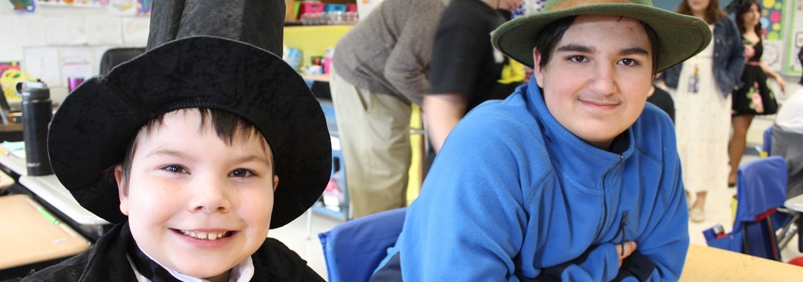 two boys wearing hats sitting at table