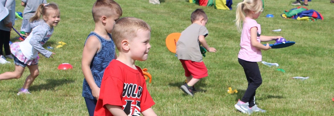 students playing with racquets and dinosaurs on field