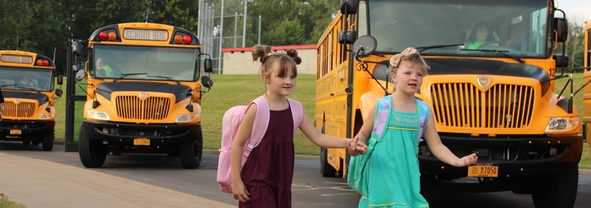 students holding hand in bus loop